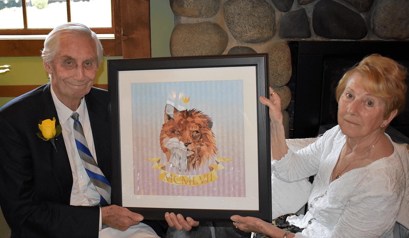 justin holmes' grandparents holding an art print at their 60th wedding anniversary